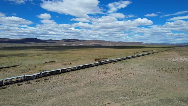 Drone side tracking shot over old train wagons and vintage telegraph poles