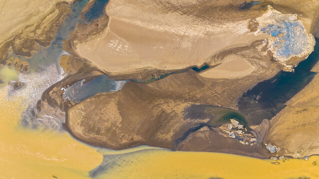 Aerial view of winding rivers carving through the tan and brown earth, creating a mesmerizing tapestry of textures and tones, Puerto Maldonado, Madre de Dios, Peru.