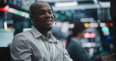 Fototapeta premium Triumphant Male Trader in Grey Shirt Shifts From Focused Data Analysis to Celebratory Mood. Sitting in Front of Advanced Trading Screens, Man Claps Hands With Wide Smile. Excitement of Stock Exchange.