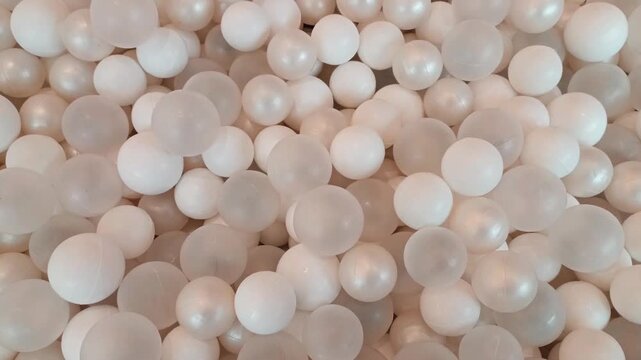 White ball pit spheres creating a dense abstract texture and clean minimal background.