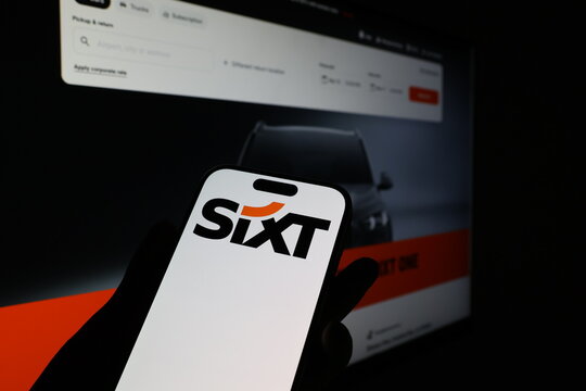 Kiel, Germany - 03-12-2026: Smartphone displaying German mobility company Sixt logo in front of companys webpage