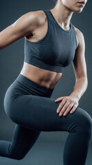 Obraz premium Fit woman performing a lunge exercise in a dark studio
