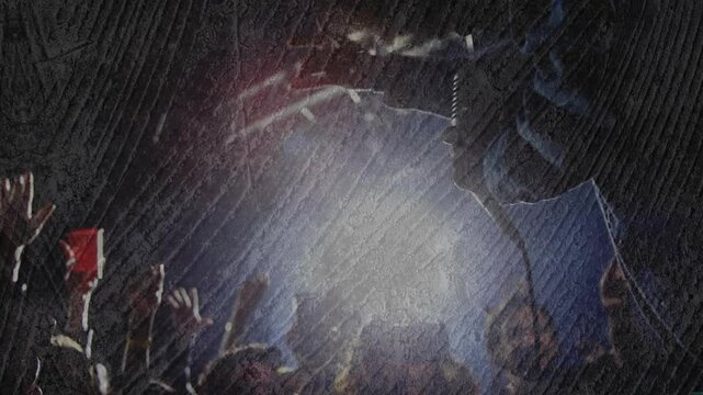 Spotlight intensifying, music crowd raising phones and carrying crowdsurfer across frame, filming