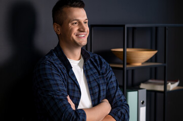 Fototapeta premium Confident man with crossed arms looking away standing in modern office interior
