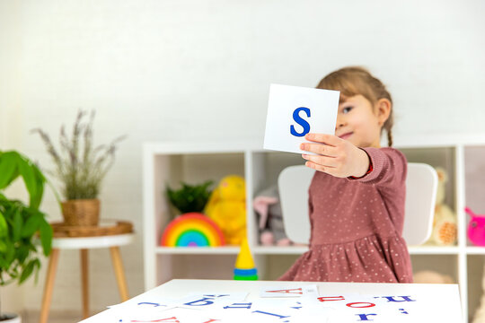 The child learns English letters. Selective focus.