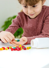 A child eats vitamin gummy candies. Selective focus.