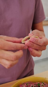 Authentic cooking process Person wrapping fresh dough for Chinese jiaozi or dim sum.