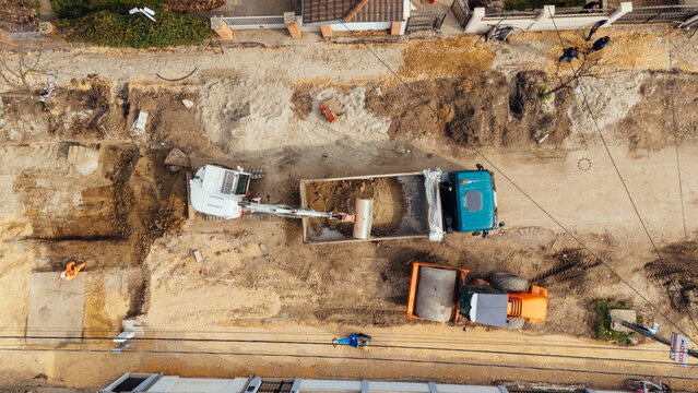 Aerial view of construction vehicles and workers amid the brown earth tones of a Belgrade street under repair, Belgrade, City of Belgrade, Serbia.