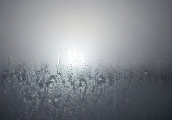 Obraz premium Condensation forming on a window pane with diffused light shining through the mist