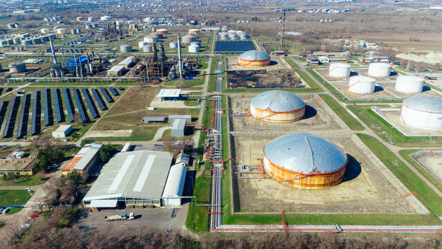 Aerial view of an industrial complex with large storage tanks and solar panels under a hazy sky, Novi Sad, Vojvodina, Serbia.