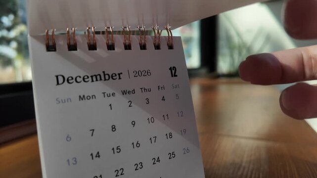 Slow motion footage of flip calendar pages for change months from november to december of the year 2026. concept of planning and starting a new month. 4k horizontal.