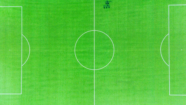 Aerial view of a vibrant green football field meticulously marked with stark white lines, a geometric symphony of sport, Novi Sad, Vojvodina, Serbia.
