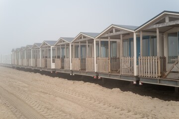 Obraz premium Row of beach houses on a foggy wijk aan zee beach