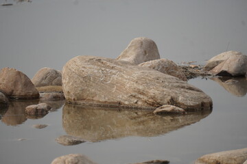 Rocks Pebbles Reflection Calm Water Shoreline Nature 4K HD Ultra image