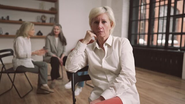 Unhappy frustrated woman in office for group therapy, looking at camera sadly. Depressed divorced lady joining support group for single senior ladies, psychological portrait, problem of aging