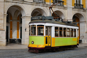 Colorful, lime-green, vintage tram line 25 operating in the central Lisbon district in Portugal.