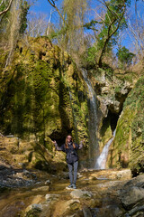 girl on the background of a large beautiful waterfall in the gorge