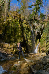 girl on the background of a large beautiful waterfall in the gorge