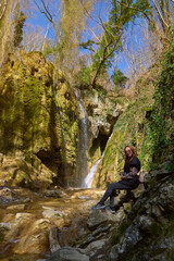 Fototapeta premium girl on the background of a large beautiful waterfall in the gorge