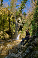 Obraz premium girl on the background of a large beautiful waterfall in the gorge