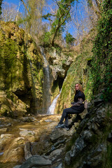 Fototapeta premium girl on the background of a large beautiful waterfall in the gorge