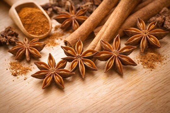 Aromatic cinnamon sticks and whole star anise on a rustic wooden background, cozy autumn spices.
