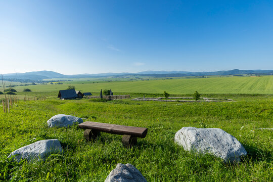 Wooden bench and rocks in green meadow, Strba, Slovakia