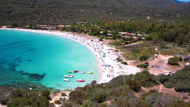 Sardinia Cala Pira beach aerial view from Saracen tower at Costa Rei turquoise sea with yachts 4k cinematic drone footage Italy Emerald coast travel destination panoramic bay landscape summer