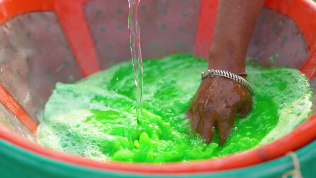 Indian farmer mixing water in fertilizer bottle 