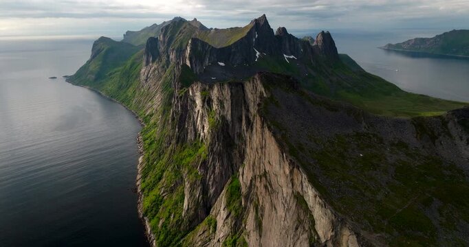 Dramatic terrain of Segla mountain during midnight sun in Fjordgard. Drone