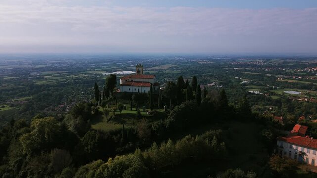 Montevecchia Sanctuary standing on a green hill with an expansive valley and sky