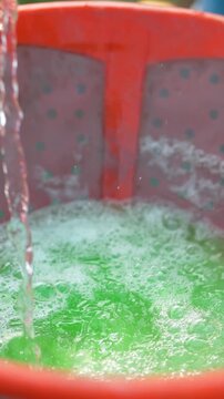 Farmer mixing water in pesticide or fertilizer powder at agriculture field 
