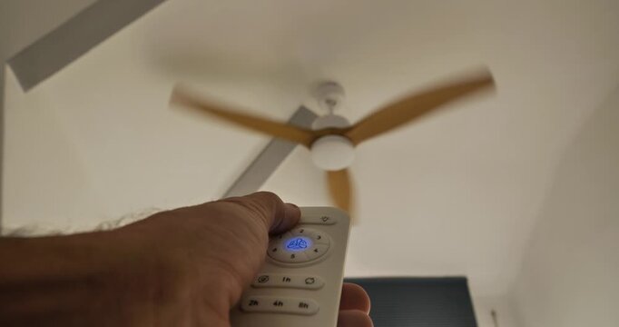 Ceiling Fan in Action: An indoor scene captures the effortless operation of a modern ceiling fan, with its blades in motion, controlled by a handheld remote.