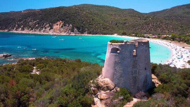 Sardinia Unreal Tropical Pira Beach Cinematic Drone 4K Video Pass Through Ancient Coastal Tower to White Sand Bay and Turquoise Sea Italy Mediterranean Paradise Aerial View 