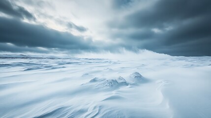 Obraz premium Dramatic winter landscape under a cloudy sky with snow and strong winds