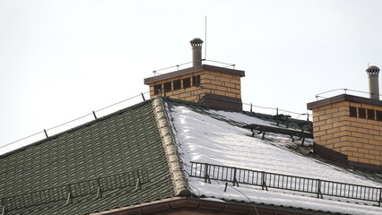 Dach domu wielorodzinnego ośnieżony z jedne strony. © tomo81