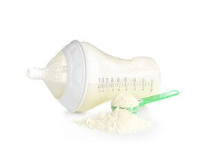 Measuring scoop with powdered baby milk formula and bottle on white background