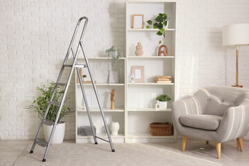 Interior of living room with stepladder, shelf units and armchair
