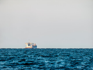 Fototapeta premium Cargo ship on Black Sea horizon with calm water and copy space