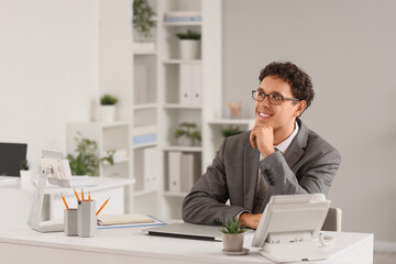 Fototapeta premium Dreaming young businessman at table in office
