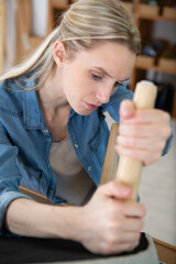 a young woman repairing chair at home
