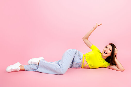Happy woman reclining on pink background in casual fashion outfit smiling confidently for lifestyle and beauty portrait