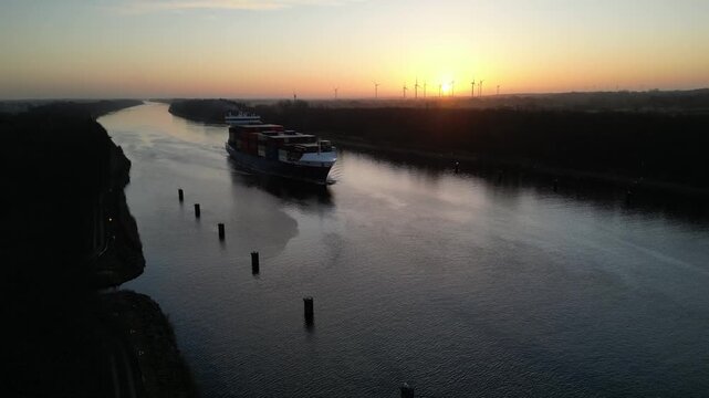 Containerschiff NORDICA f&auml;hrt bei Sonnenaufgang im Nord-Ostsee-Kanal 