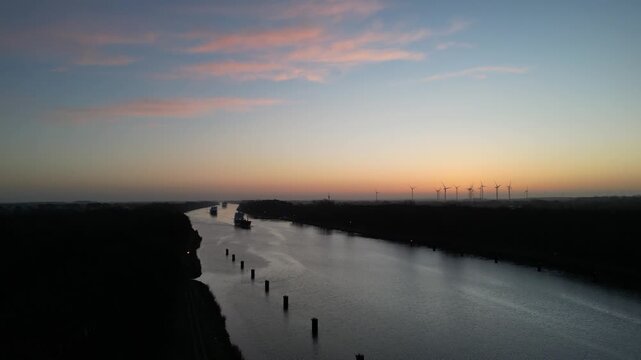 Schiffe fahren bei Sonnenaufgang durch den Nord-Ostsee-Kanal