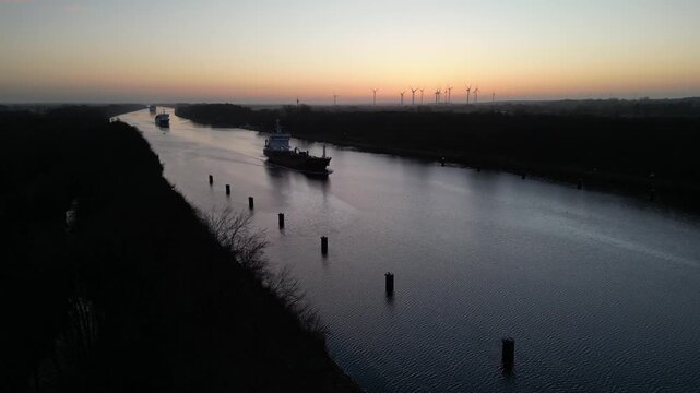 Schiffe fahren bei Sonnenaufgang durch den Nord-Ostsee-Kanal
