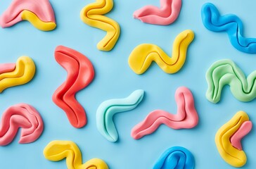 Obraz premium Colorful playdough swirl pattern flat lay on light blue background vibrant clay texture abstract creative design