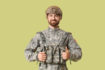 Naklejka premium Young happy male soldier in uniform on green background