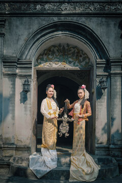 Beautiful Burmese women with traditional string puppet Marionette at ancient temple.