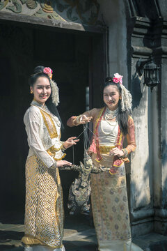 Beautiful Burmese women with traditional string puppet Marionette at ancient temple.