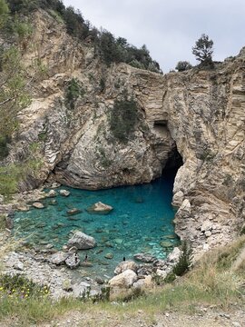 Rocky cliff framing turquoise cove with clear shallow water